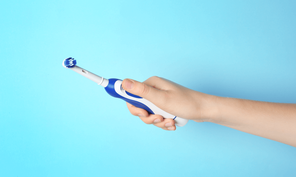 hand holding electric toothbrush